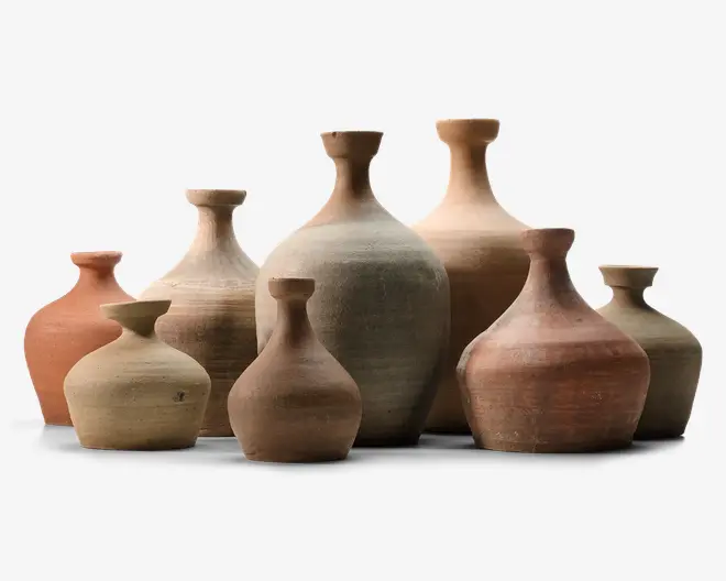 En samling rustikke keramikvaser i jordfarver som beige, terrakotta og brun, med runde kroppe, smalle halse og korte, let udadbuede kanter på sort baggrund.