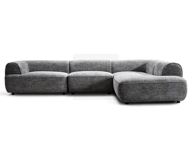 Lav, grå betrukket hjørnesofa med afrundede armlæn, tre store siddehynder og en chaiselong-lignende forlængelse på højre side.