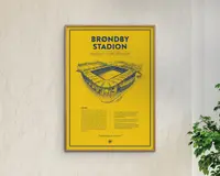 En indrammet plakat med en klar gul baggrund og en tynd sort kant. Plakaten viser en detaljeret stregtegning af et stadion i blå blæk, placeret centralt. Over illustrationen står der med fed blå skrift 'BRØNDBY STADION.' Under tegningen er der tekstafsnit i mindre blå skrift, herunder en historiedel og et citat. Designet er minimalistisk og moderne med en stærk kontrast mellem den gule baggrund og de blå elementer.