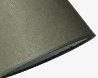 Nærbillede af en lampeskærm med olivengrønt tekstil på ydersiden og en glat, lidt mørkere grøn kant langs bunden. Indersiden af skærmen ser ud til at være foret med et lyst materiale.