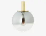 En moderne pendellampe med en kugleformet glasskærm, der har en diskret farveovergang fra klar i bunden til røgfarvet i toppen. Lampen har en messing- eller guldfarvet metalstang og top, hvilket giver et stilrent og elegant udtryk. Pæren er synlig inde i lampen, hvilket understreger det moderne design.
