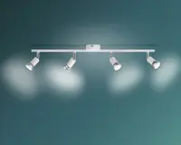 Et moderne loftmonteret skinnespot med en slank, lige metalstang i sølvfinish. Lampen har fire justerbare spotlys, hver med en cylindrisk form og i hvid og sølv. Spotlysene kan drejes individuelt for at belyse forskellige områder i rummet. Designet er minimalistisk og moderne, velegnet til køkkener, stuer eller kontorer.