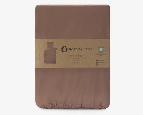 Et pænt sammenfoldet sengesæt i en afdæmpet brun farve, indpakket i et genanvendeligt papirbånd. Emballagen fremhæver, at stoffet er lavet af 100% økologisk bomuld og er GOTS-certificeret, hvilket sikrer miljøvenlig og bæredygtig produktion. Overfladen ser glat og blød ud, hvilket indikerer en behagelig tekstur. Mærkaten indeholder vaskeanvisninger og sociale medieikoner for mærket Nordisk Tekstil.
