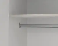 Nærbillede af et klædeskab indvendigt med en solid metal bøjlestang monteret mellem to vægge og en hvid hylde placeret ovenover til ekstra opbevaring. Overfladerne er glatte, og designet er minimalistisk, hvilket giver god plads til ophængning af tøj og opbevaring af ting på hylden.