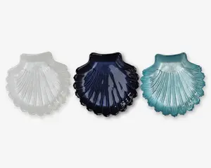 Sæt med tre skålformede fade i glas, hver med en rillet, tekstureret overflade, der efterligner en kammuslingskal. Sættet indeholder én skål i gennemsigtig hvid, én i mørkeblå og én i lyseblå/aquafarvet. Hver skål har en blank overflade og let hævede kanter, velegnet til servering af småting eller som dekorative elementer.