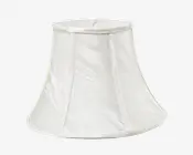 En klassisk klokkeformet lampeskærm lavet af hvidt stof med et diskret tekstureret mønster. Skærmen har lodrette stofpaneler adskilt af smalle syninger og en let udvidet bundkant med forstærket kant både foroven og forneden for ekstra stabilitet.