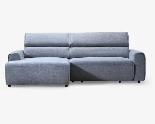 Lysegrå polstret hjørnesofa med venstrevendt chaiselong, brede afrundede armlæn, lav ryg og rene vandrette syninger i hynderne.