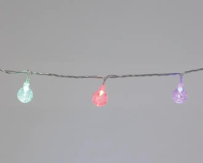 En lyskæde med små, runde pærer, der har en tekstureret, krakeleret overflade. Pærerne lyser i forskellige farver, herunder grøn, rød og lilla, og er jævnt fordelt langs en tynd, snoet ledning. Designet giver et festligt og moderne udtryk, velegnet til dekoration både inde og ude.