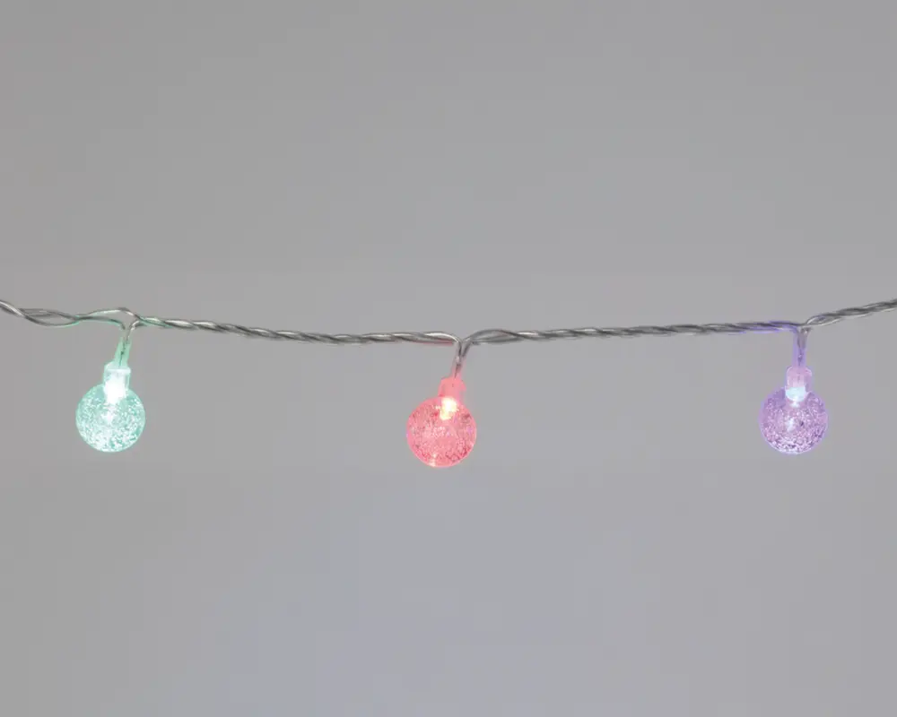 En lyskæde med små, runde pærer, der har en tekstureret, krakeleret overflade. Pærerne lyser i forskellige farver, herunder grøn, rød og lilla, og er jævnt fordelt langs en tynd, snoet ledning. Designet giver et festligt og moderne udtryk, velegnet til dekoration både inde og ude.