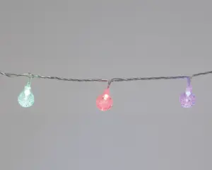 En lyskæde med små, runde pærer, der har en tekstureret, krakeleret overflade. Pærerne lyser i forskellige farver, herunder grøn, rød og lilla, og er jævnt fordelt langs en tynd, snoet ledning. Designet giver et festligt og moderne udtryk, velegnet til dekoration både inde og ude.
