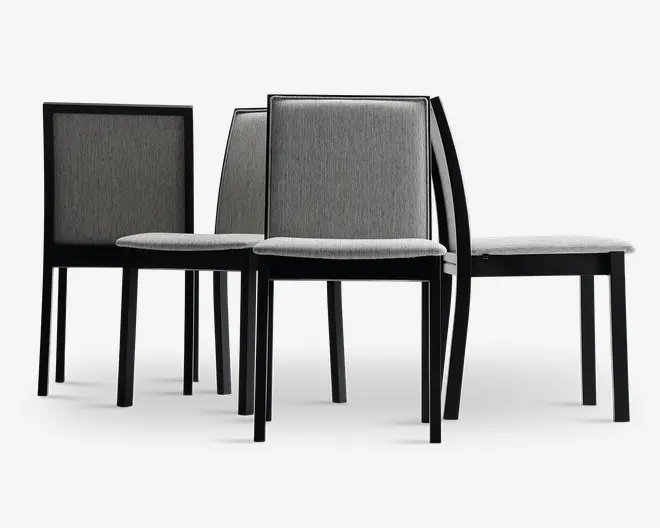 Sæt med fire moderne stole med lige ryg og firkantede sæder. Stolene har en slank sort træramme og er polstret med lysegråt stof på både sæde og ryglæn. Designet er minimalistisk og stolene kan stables, hvilket gør dem velegnede til spise- eller konferencelokaler.