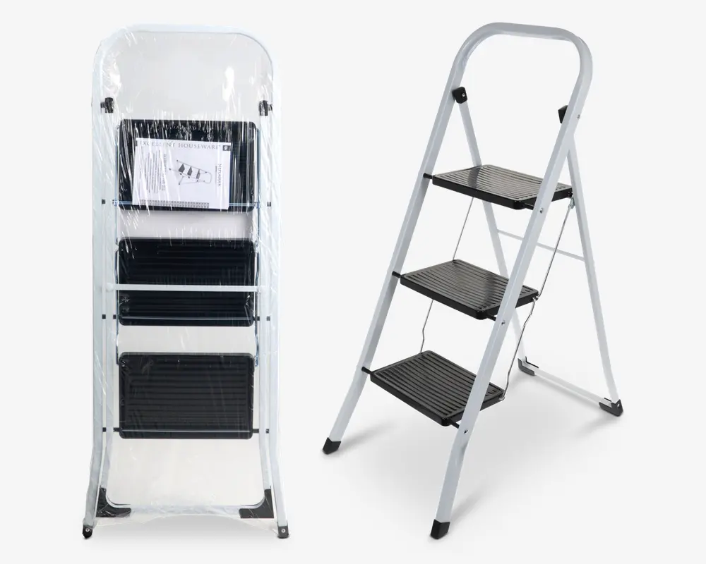 En tretrins foldestige med en robust hvid metalramme og brede, skridsikre sorte trin. Stigen vises både sammenfoldet til opbevaring, indpakket i beskyttende plast, og helt udfoldet til brug. Trinene har en rillet overflade for ekstra greb, og fødderne er udstyret med sorte gummidutter for stabilitet og beskyttelse af gulvet. En brugsanvisning er synlig i den sammenfoldede version.