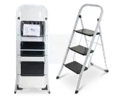 En tretrins foldestige med en robust hvid metalramme og brede, skridsikre sorte trin. Stigen vises både sammenfoldet til opbevaring, indpakket i beskyttende plast, og helt udfoldet til brug. Trinene har en rillet overflade for ekstra greb, og fødderne er udstyret med sorte gummidutter for stabilitet og beskyttelse af gulvet. En brugsanvisning er synlig i den sammenfoldede version.
