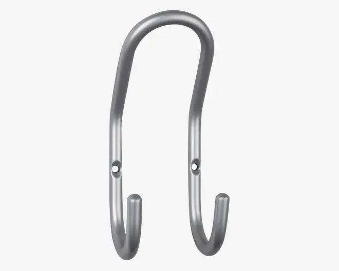 Et robust, sølvfarvet metalophæng med en glat, afrundet finish. Ophænget har to monteringshuller til sikker fastgørelse på en væg eller anden overflade, og dets dobbeltkrogede design gør det muligt at hænge flere genstande op. Enderne på krogene er let opadbøjede for at forhindre, at ting glider af.