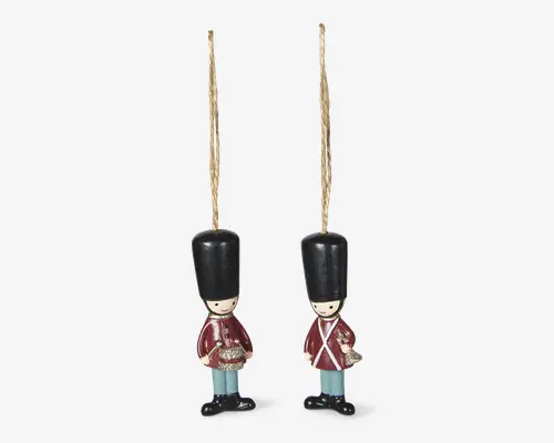 Par små hængende gardefigurer med guldsnor, sorte høje hatte, røde frakker, lyseblå bukser og sorte sko.