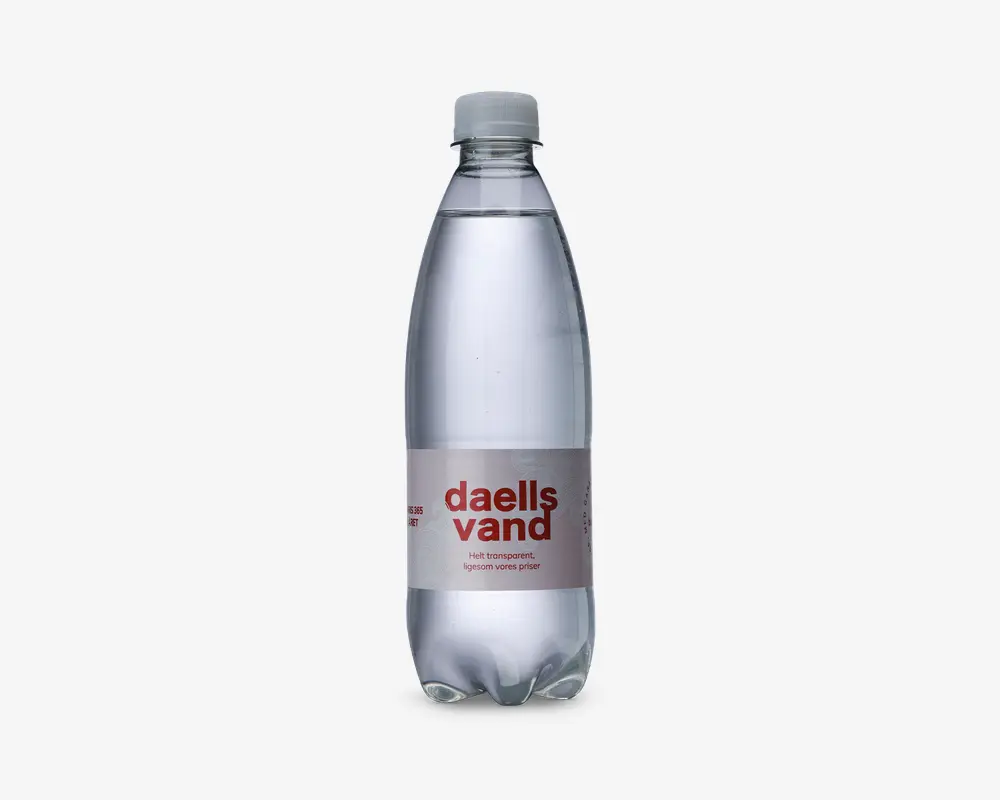 En klar plastflaske med hvidt skruelåg, fyldt med gennemsigtig væske. Flasken har et minimalistisk mærkat med fed rød tekst og mindre tekst nedenunder, hvilket giver et enkelt og moderne udtryk. Flasken er let formet for bedre greb og har en glat, afrundet bund.