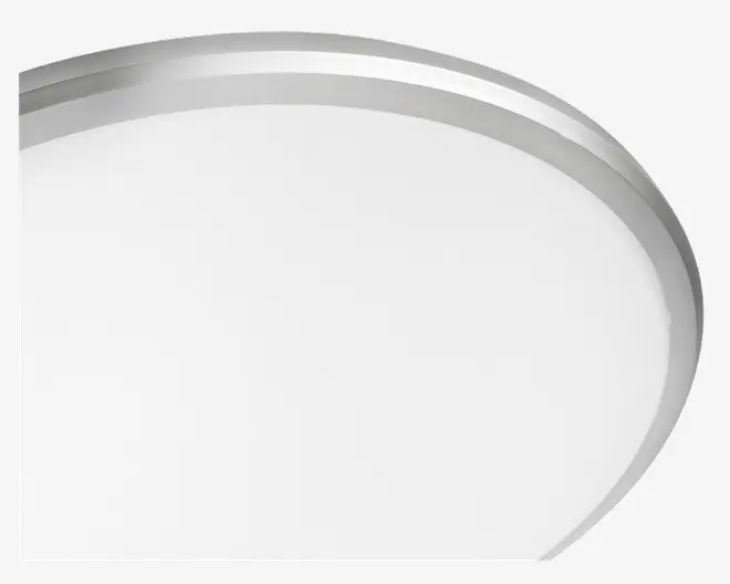 Nærbillede af et rundt objekt med en glat, hvid overflade og en metallisk sølvkant. Kanten er let forhøjet og har en poleret finish, hvilket giver objektet et moderne og stilrent udseende.