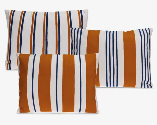 Sæt med fire rektangulære puder med et markant stribet mønster. Striberne veksler mellem brændt orange, marineblå og hvid i forskellige bredder, hvilket giver et moderne og dynamisk udtryk. Stoffet ser glat og tæt vævet ud, velegnet til både dekoration og praktisk brug. Farvekombinationen giver et varmt og samtidig moderne udtryk, perfekt til at tilføje farve til enhver siddeplads.