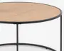 Rundt bord med en lys træbordplade og en tynd, sort metalramme. Bordpladen har en glat overflade, og benene er slanke og minimalistiske, forbundet af en cirkulær støtte nederst.