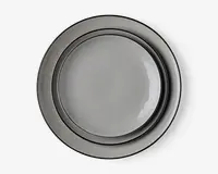 Sæt med tre runde tallerkener i forskellige størrelser, alle med en glat, blank grå overflade. Tallerkenerne har et minimalistisk design med let hævet kant og et diskret, moderne udtryk. Overfladerne er jævne og reflekterende, hvilket giver dem et stilrent udseende.