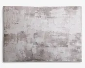 Rektangulært tæppe med et moderne abstrakt mønster i lysegrå, beige og off-white nuancer. Designet har et slidt, tekstureret udseende, hvilket giver det et moderne og alsidigt udtryk, der passer til forskellige indretningsstile. Overfladen ser blød og glat ud med diskrete farvevariationer.
