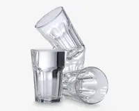 Tre klare glasdrikkeglas med et facetteret design, der har lodrette riller langs siderne for bedre greb. Glassene har en let udvidet kant og en tyk, robust bund, hvilket gør dem velegnede til daglig brug. Den gennemsigtige finish fremhæver glassets klarhed og kvalitet.