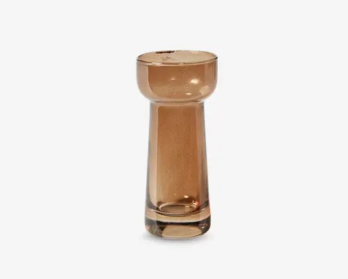 Højt, cylindrisk glas med bred, afrundet kant og en tyk, solid bund. Glasset har en varm ravfarvet tone og en glat, blank overflade, hvilket giver det et moderne og elegant udtryk.