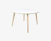 Et rundt bord med en glat, hvid bordplade og fire lyse træben, der er let skråtstillede udad. Designet er minimalistisk og moderne med rene linjer og et enkelt, funktionelt udtryk.