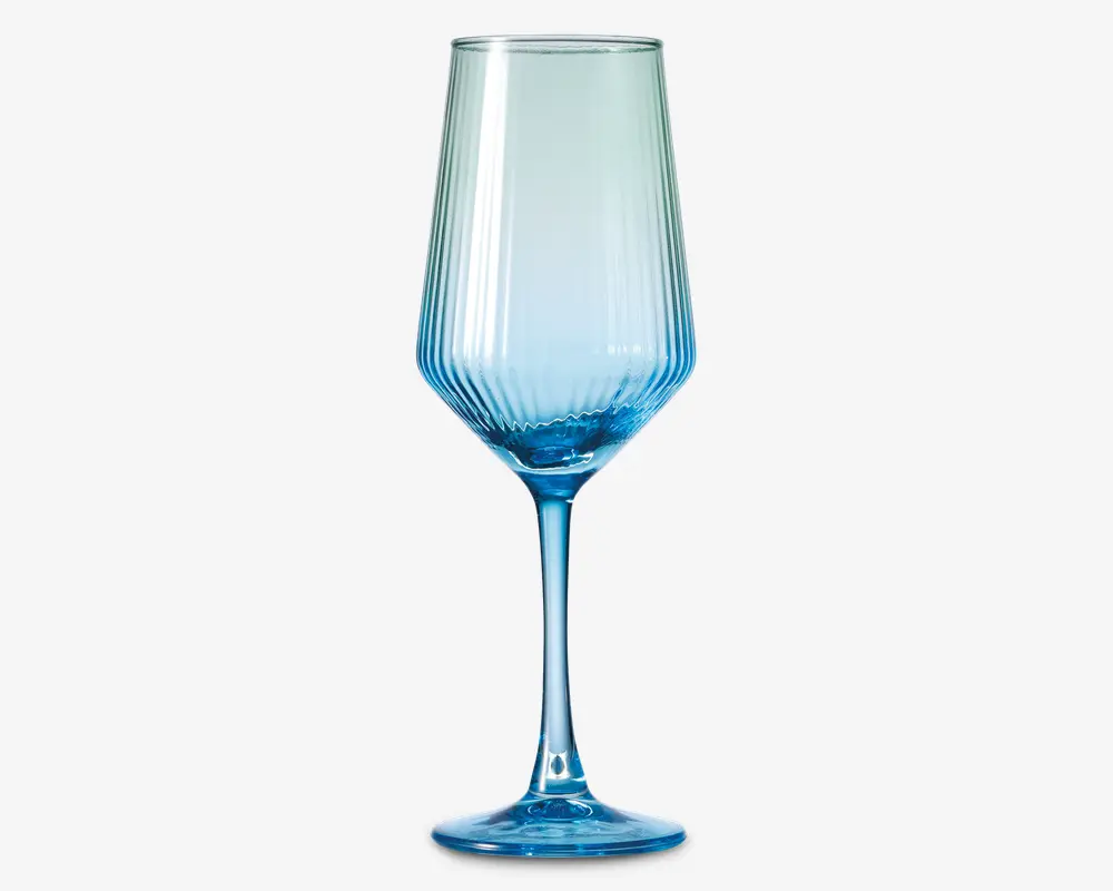 Højt glas med blå nuance, lang stilk og bred, vinklet skål. Skålen har lodrette rillede linjer, der giver tekstur og et dekorativt udtryk. Bunden er rund og solid og matcher glassets blå farve.