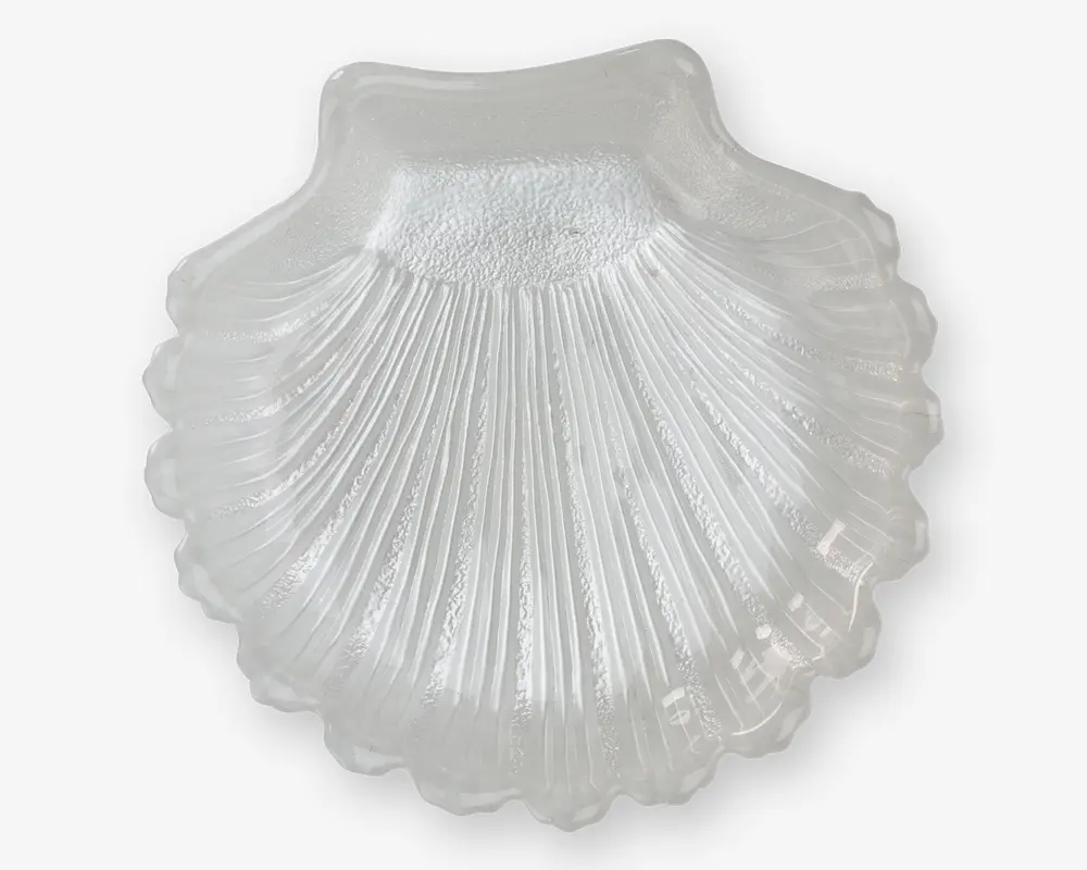Klar glasskål formet som en kammuslingeskal med detaljerede riller og en tekstureret overflade, der giver et realistisk udseende. Kanterne er blødt bølgede, og glasset har en glat, blank finish.