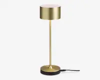 Slank, moderne lampe med børstet guldfinish, cylindrisk lampeskærm, tynd lodret stang og rund, tung fod. Lampen har et minimalistisk design og berøringskontrol på toppen af skærmen.