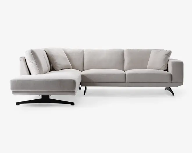 Moderne L-formet hjørnesofa med lysegråt betræk, rene linjer og bløde sæde- og ryghynder. Sofaen har en venstrevendt chaiselong, slanke sorte metalben og leveres med flere matchende pyntepuder for ekstra komfort.