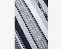 Et nærbillede af et vævet tekstil med horisontale striber i sort, grå og hvid. Mønsteret indeholder både ensfarvede striber, prikmønstre og geometriske diamantmotiver. Stoffet ser tykt og slidstærkt ud med en let grov overflade.