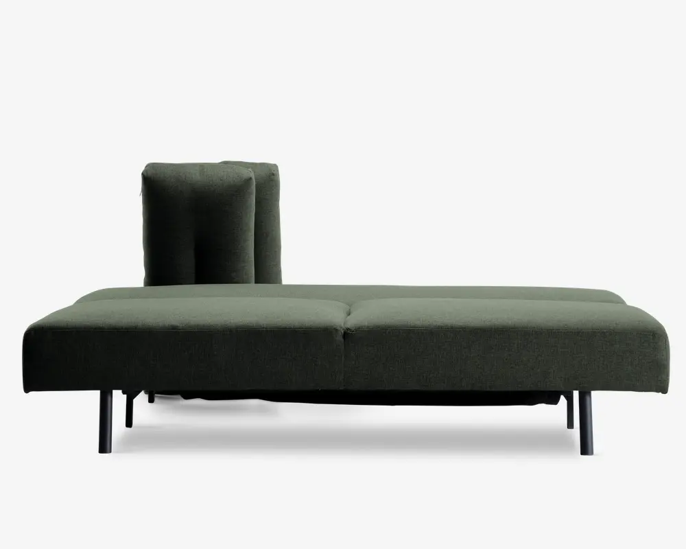 Et moderne, minimalistisk møbel med dybgrønt polstret sæde og ryglæn. Sædet er bredt og fladt med en diskret syning i midten, og ryglænet er placeret i den ene side og har en matchende pude for ekstra komfort. Benene er slanke og mørke, hvilket giver møblet et elegant og løftet udtryk.