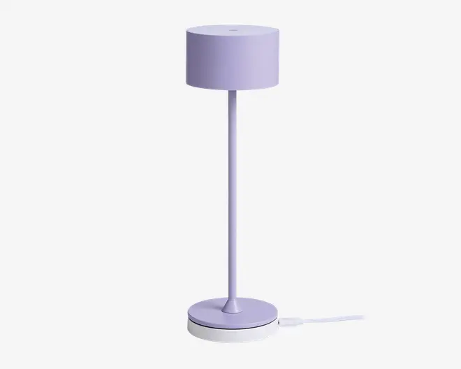 Høj, slank lampe med cylindrisk lampeskærm og fod, alt i en blød pastel-lilla farve. Lampen har et minimalistisk design med glatte overflader og rene linjer, velegnet til moderne indretning.
