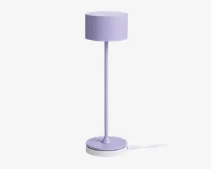 Høj, slank lampe med cylindrisk lampeskærm og fod, alt i en blød pastel-lilla farve. Lampen har et minimalistisk design med glatte overflader og rene linjer, velegnet til moderne indretning.