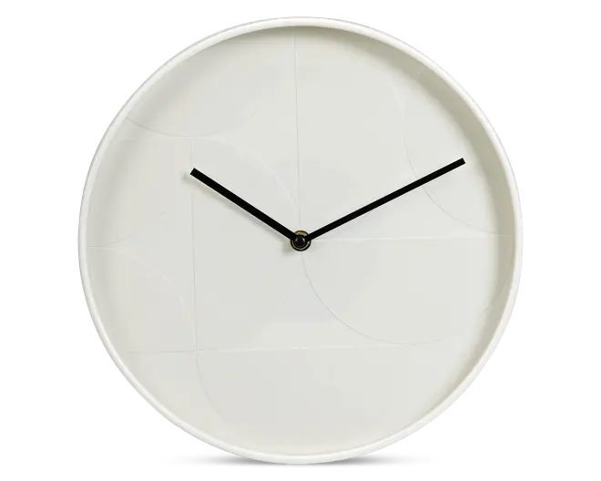 Minimalistisk rund vægur med mat hvid urskive og diskrete geometriske mønstre. Uret har tynde sorte time- og minutvisere uden tal eller markeringer på skiven, hvilket giver et rent og moderne udtryk.