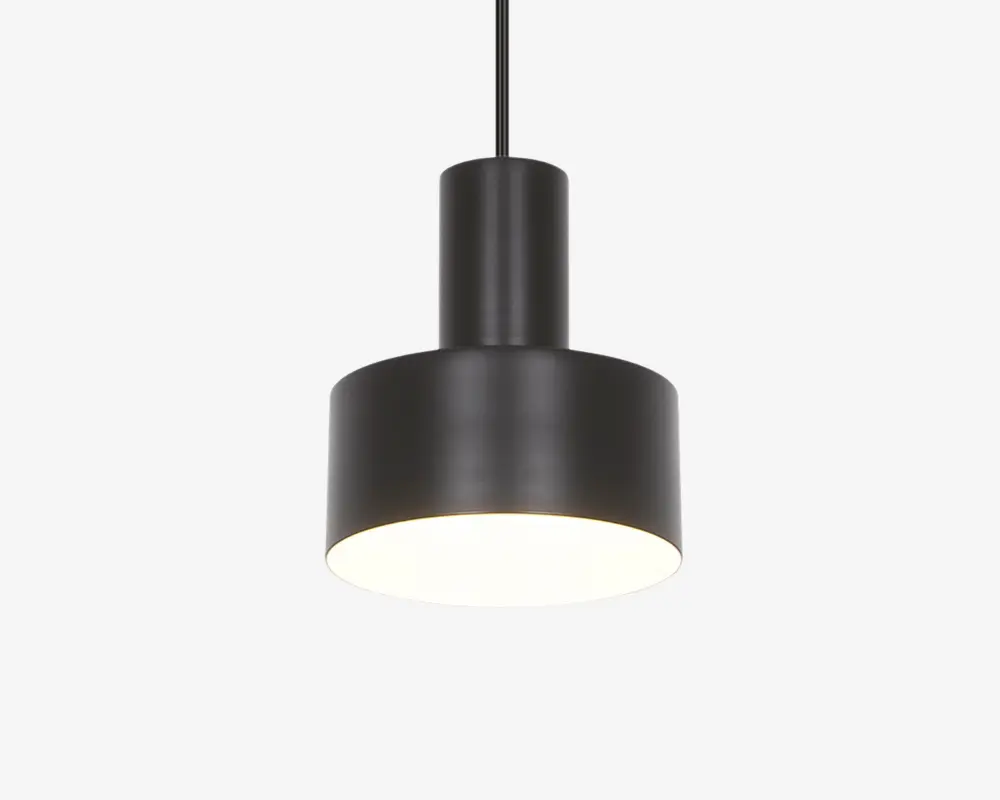 En moderne pendellampe med en mat sort cylindrisk metalskærm. Designet har en bredere nederste del og en smallere øverste del, hvilket giver en trinvist silhuet. Lampen hænger i en sort ledning, og undersiden er åben, så lyset skinner direkte nedad. Overfladen er glat, og stilen er minimalistisk, velegnet til moderne indretning.