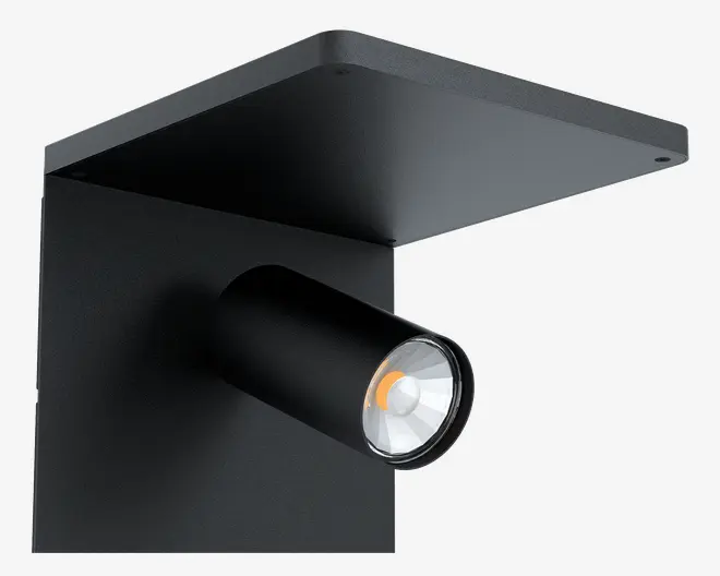 En moderne, mat sort vægmonteret spotlampe med et cylindrisk, justerbart lampehoved. Armaturet har en flad, rektangulær top og bagplade, hvilket giver et stilrent og minimalistisk udtryk. Spotlampen har en klar linse og et synligt LED-element indeni, velegnet til fokuseret belysning i moderne indretninger.