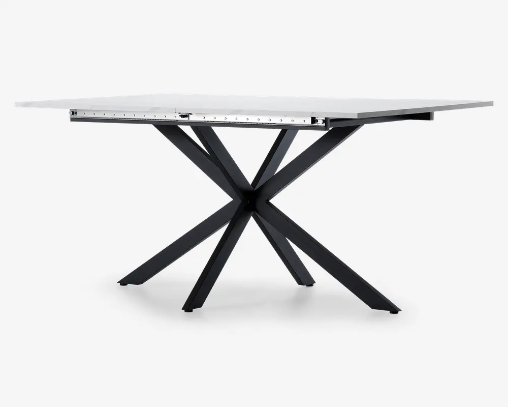 Rektangulært bord med en glat, hvid bordplade og en markant sort metalbase med fire skråtstillede ben, der krydser hinanden i midten og skaber et moderne, geometrisk udtryk. Bordet fremstår robust og har et stilrent design, der passer til forskellige indretninger.