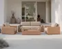 Udendørs loungesæt bestående af en trepersoners sofa, to lænestole og et rektangulært sofabord, alle med flettet rattan-lignende stel i en naturlig lysebrun farve. Hynderne er tykke og betrukket med et lyst beige stof, hvilket giver et komfortabelt og indbydende udtryk. Designet er moderne og minimalistisk, velegnet til terrasser eller haveområder.
