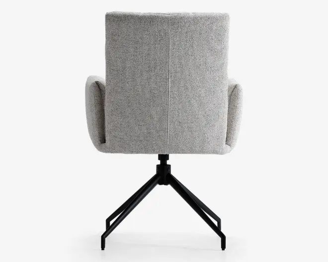 Billedet viser bagsiden af en stol med lysegråt, tekstureret stofbetræk. Stolen har en høj, rektangulær ryg og let buede, polstrede armlæn. Basen er lavet af sort metal med fire ben, hvilket giver stabilitet og et moderne udtryk. Syningen er synlig ned langs midten af ryglænet og tilføjer en diskret designdetalje.