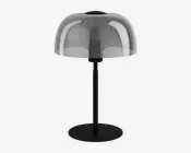 En moderne bordlampe med en rund, flad sort fod og en lige sort stang. Lampen har en kuppelformet, halvgennemsigtig skærm i røgfarvet glas, der dækker pæren og giver et stilrent og moderne udtryk. Designet er minimalistisk med rene linjer og en glat overflade.