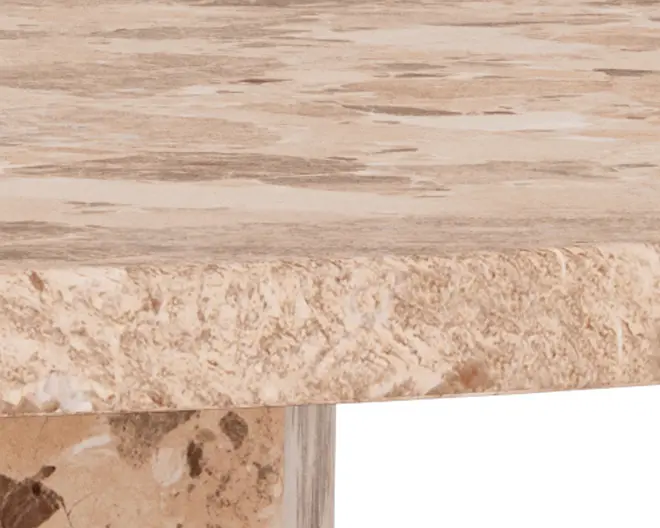 Nærbillede af en tyk, rund bordplade med naturlig stenstruktur. Overfladen er glat og poleret med beige og lysebrune nuancer, mens kanten viser en mere rå, tekstureret stenoverflade. Basen er også lavet af sten og har et mix af lyse og mørkebrune mønstre.