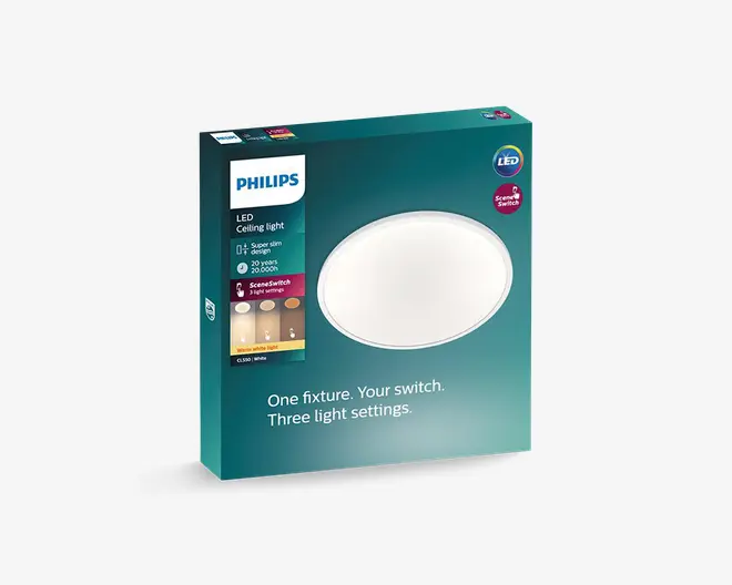 Forsiden af en Philips LED-loftlampeæske i turkis med en stor rund hvid lysplade, Philips-logo, LED- og SceneSwitch-mærker samt tekst, der fremhæver slankt design, 20 års levetid og tre lysindstillinger.