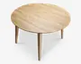 Rundt bord med en glat, lys træfinish. Bordpladen har synlige åremønstre i træet og understøttes af fire lige, tilspidsede ben. Designet er minimalistisk og moderne med rene linjer og et naturligt udtryk.