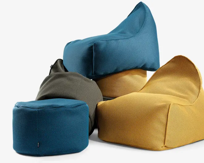 En gruppe moderne sækkestole i forskellige former og størrelser, lavet af tekstureret stof. Farverne inkluderer turkisblå, sennepsgul og mørkegrå. Stolene har formstøttede rygge for ekstra støtte og et afslappet, uformelt udseende, der egner sig til afslapning. Stoffet ser slidstærkt ud, og syningerne er forstærkede for øget holdbarhed.