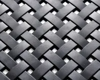 Nærbillede af et tæt vævet mønster lavet af flade, mat sorte strimler. Strimlerne er flettet sammen i et over-under kurveflet-design, hvilket skaber en tekstureret og holdbar overflade. Materialet virker robust, og vævningen er ensartet, hvilket giver både styrke og et moderne udtryk.