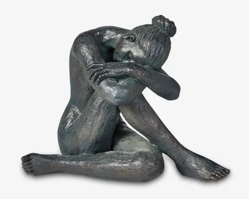 En detaljeret bronzeskulptur af en siddende kvinde med en tekstureret overflade. Hun sidder med det ene ben strakt og det andet bøjet, armene krydset og hvilende på knæene, og hovedet sænket ned mod armene. Håret er sat op i en knold, og figuren udstråler en eftertænksom eller indadvendt stemning. Overfladen har et let patineret, vejrbidt udtryk, som fremhæver de fine detaljer i form og muskulatur.