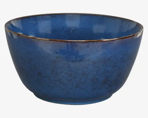 Rund keramikskål med en dybblå, let plettet glasur. Kanten har en diskret brun accent, hvilket giver skålen et håndlavet, rustikt udtryk. Både inderside og yderside har en blank finish, og skålen har en blødt buet form med en stabil bund.